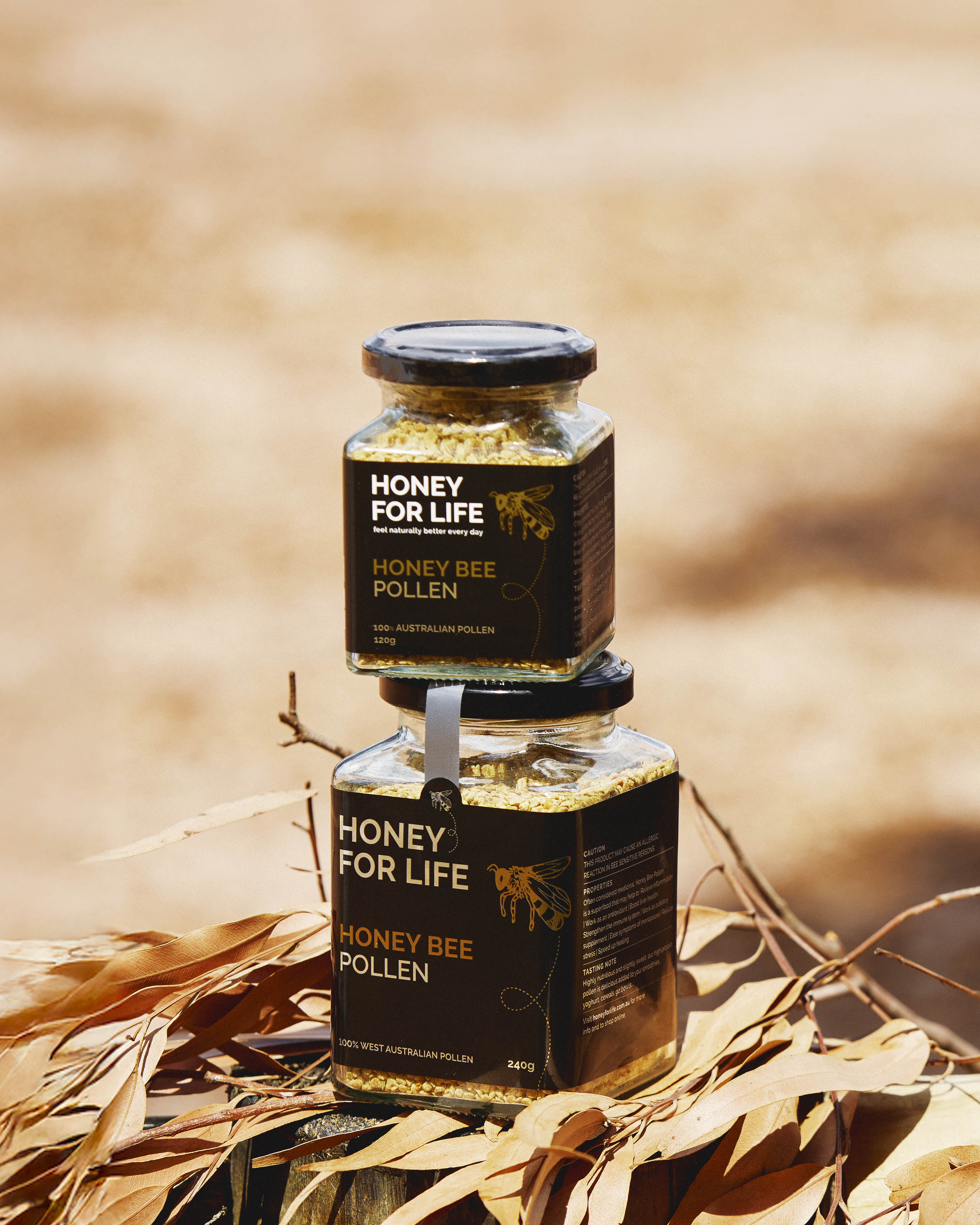 Two jars of 'Honey for Life' honey bee pollen on a blurred natural background