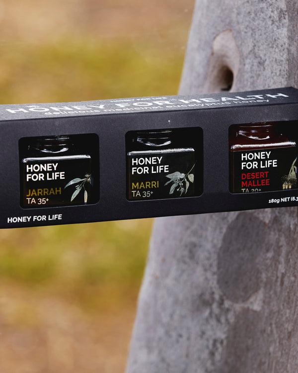 Packaging of 'Honey for Life' honey with tree in the background