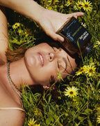 Jesinta lying in the wildlflowers with a jar of wildflower honey