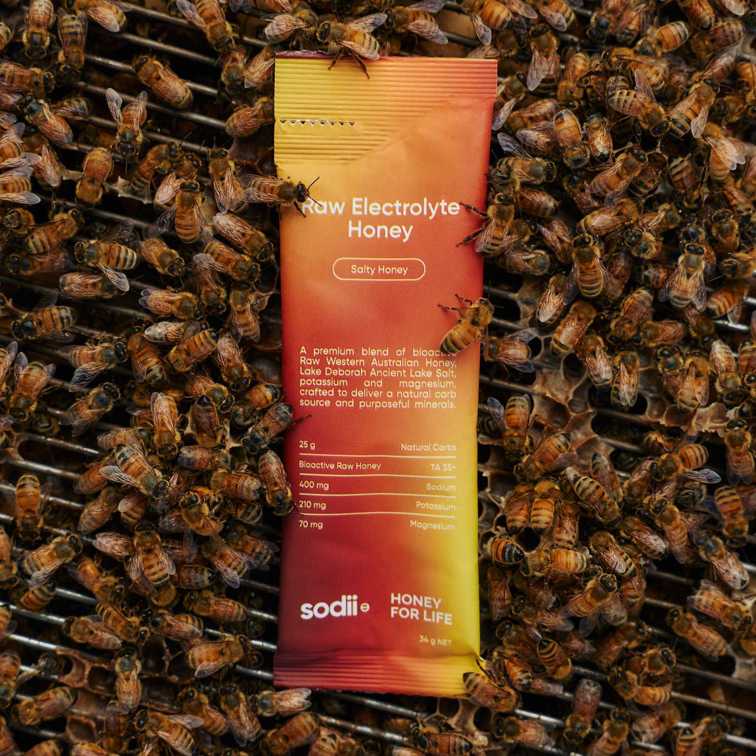 Raw Electrolyte Honey sachet held in a sunlit field