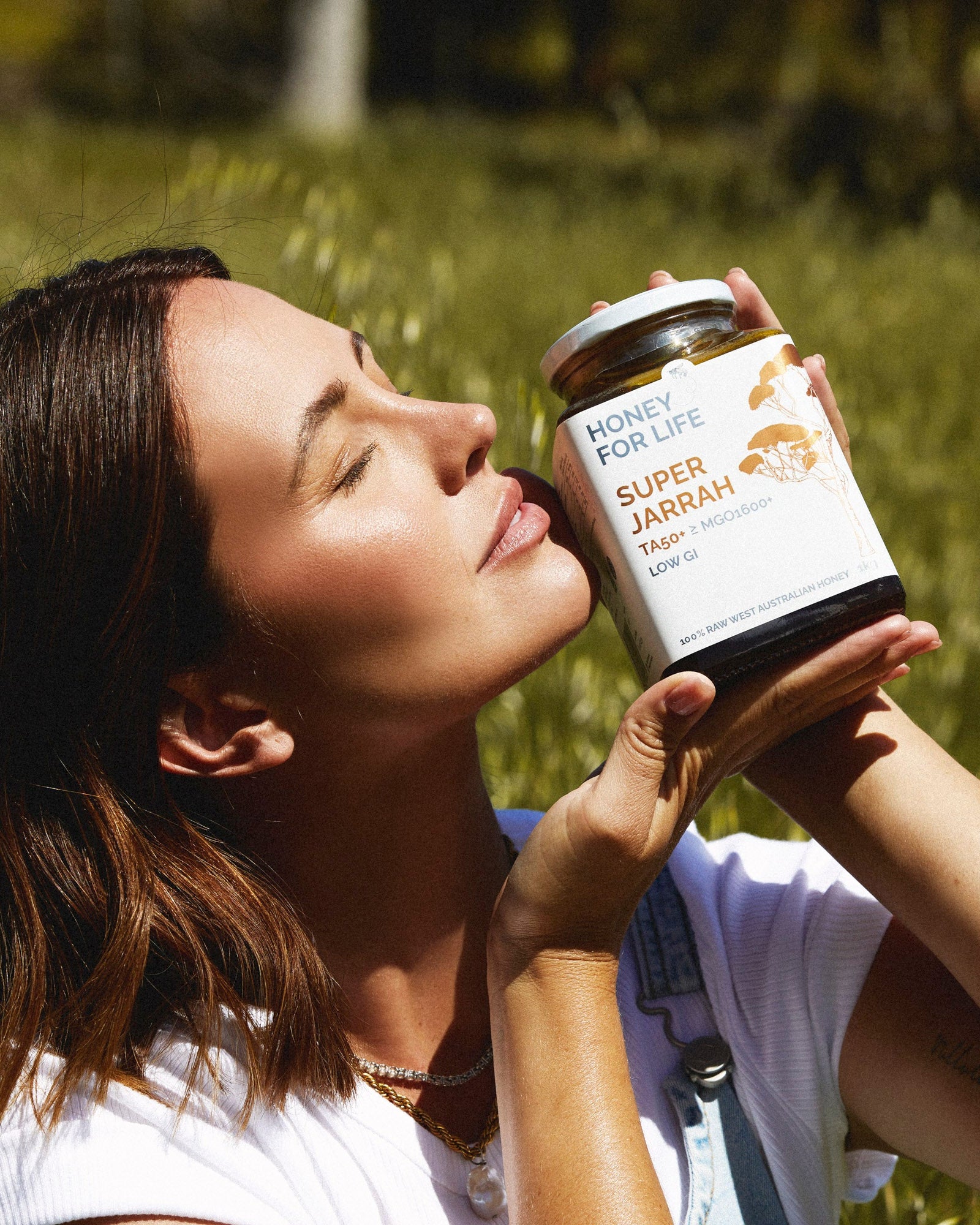 Jesinta Franklin holding a jar of 'Super Jarrah' in a grassy field